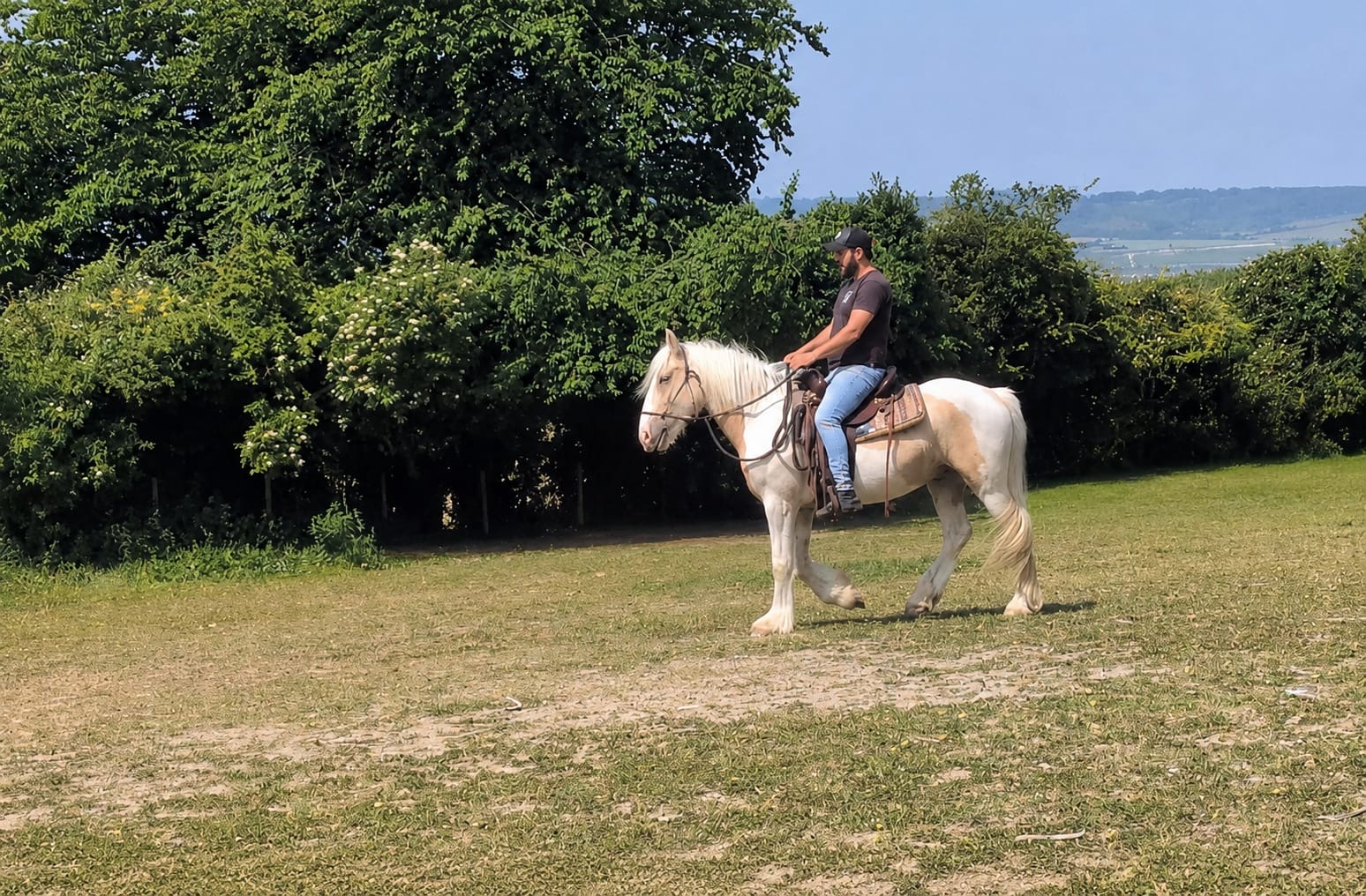 Moa riding a light-coloured horse during training